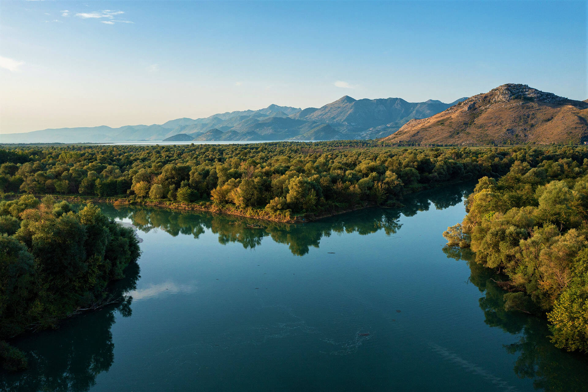 Panoramic landscape of Skadar Lake National Park with the Morača River and surrounding mountains in Montenegro.